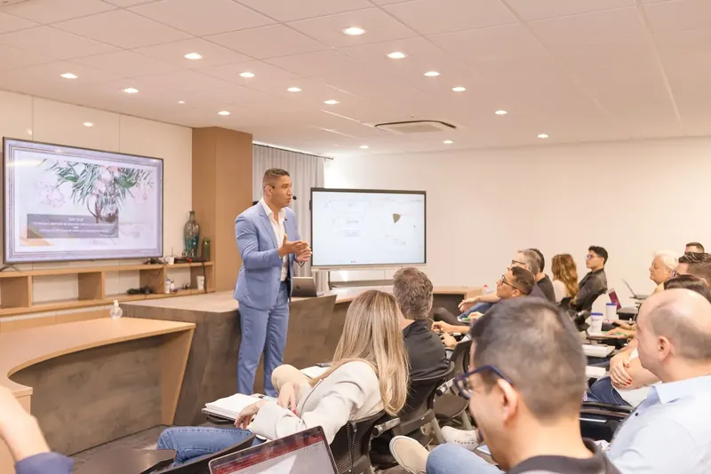 Lúcio diante das telas, com a turma em primeiro plano
